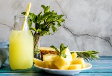 Bright yellow tropical smoothie in a glass with a straw