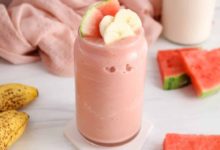 Refreshing watermelon smoothie in a glass with fruit around