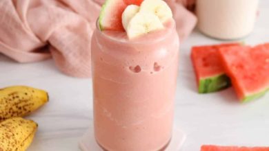 Refreshing watermelon smoothie in a glass with fruit around