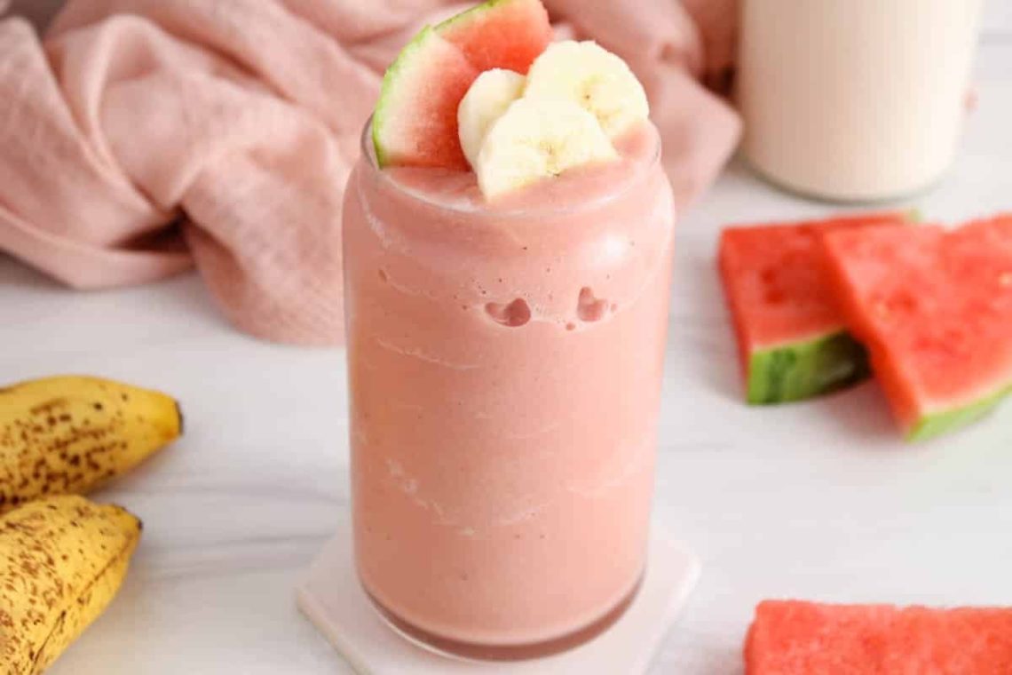 Refreshing watermelon smoothie in a glass with fruit around